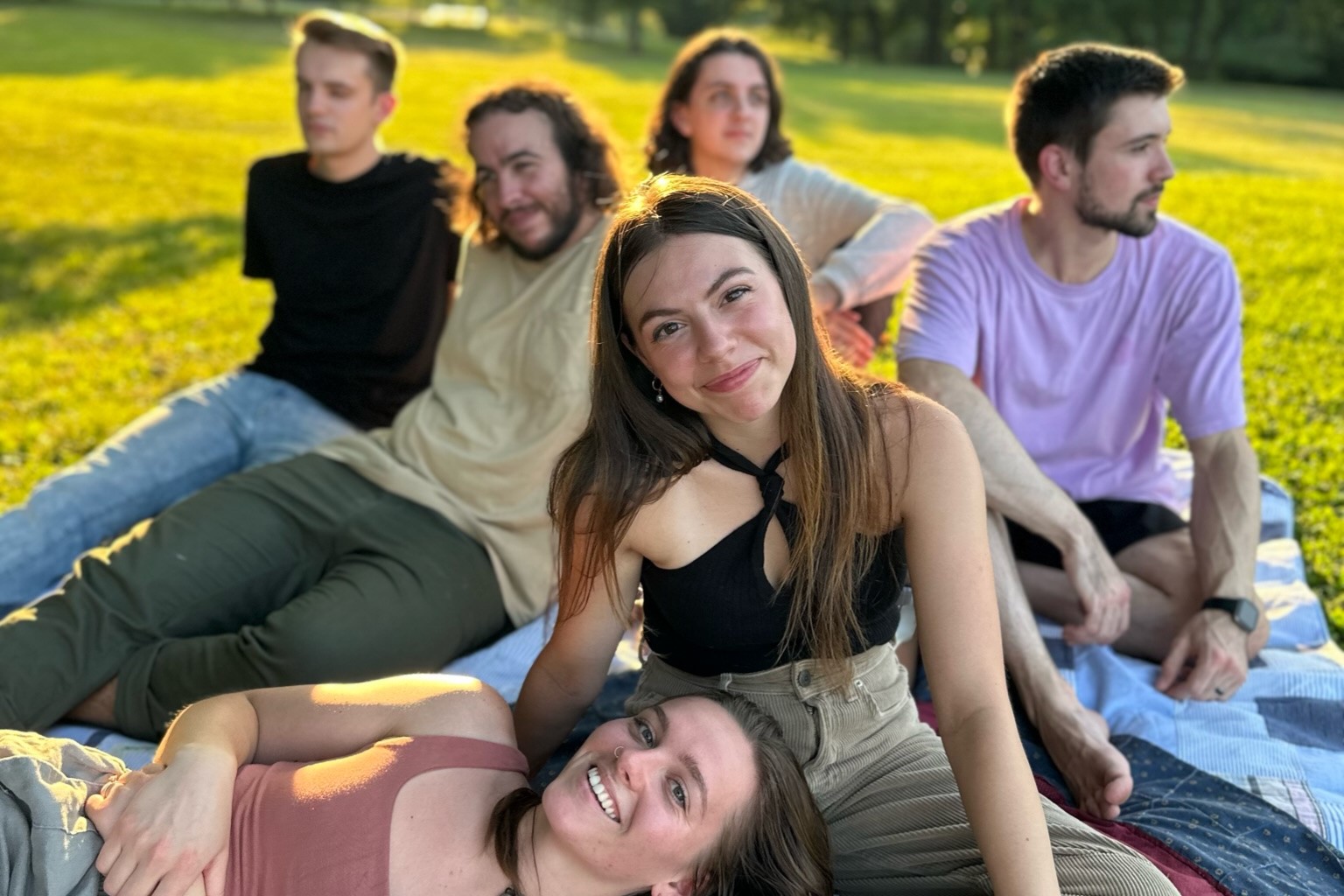 Cherry Park band members sitting on a picnic blanket